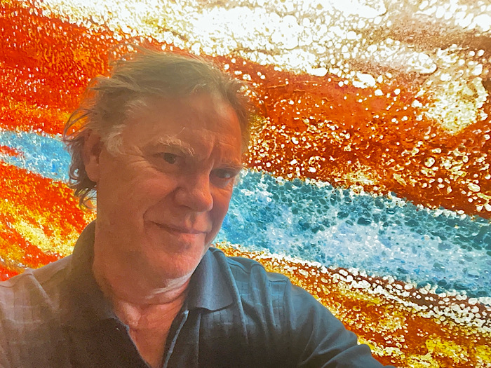 headshot of the artist in front of the window