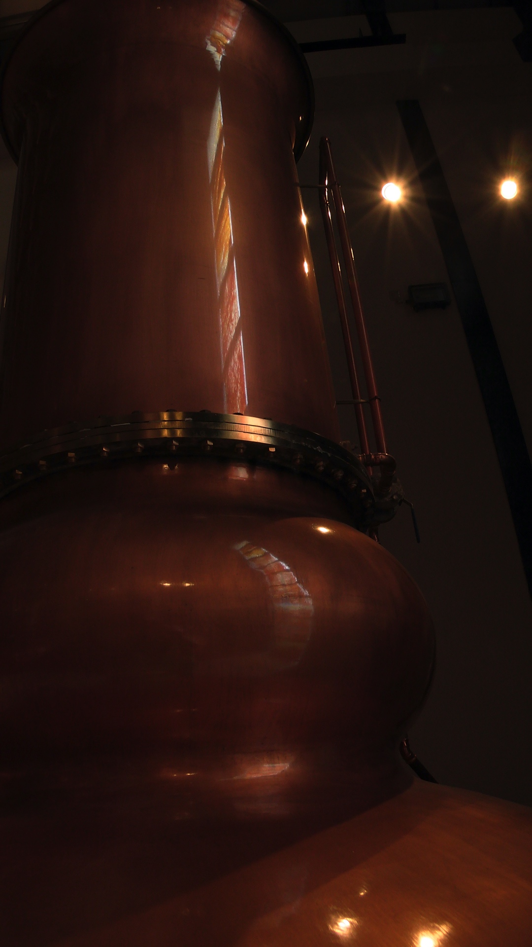 reflection of window in one of the copper stills
