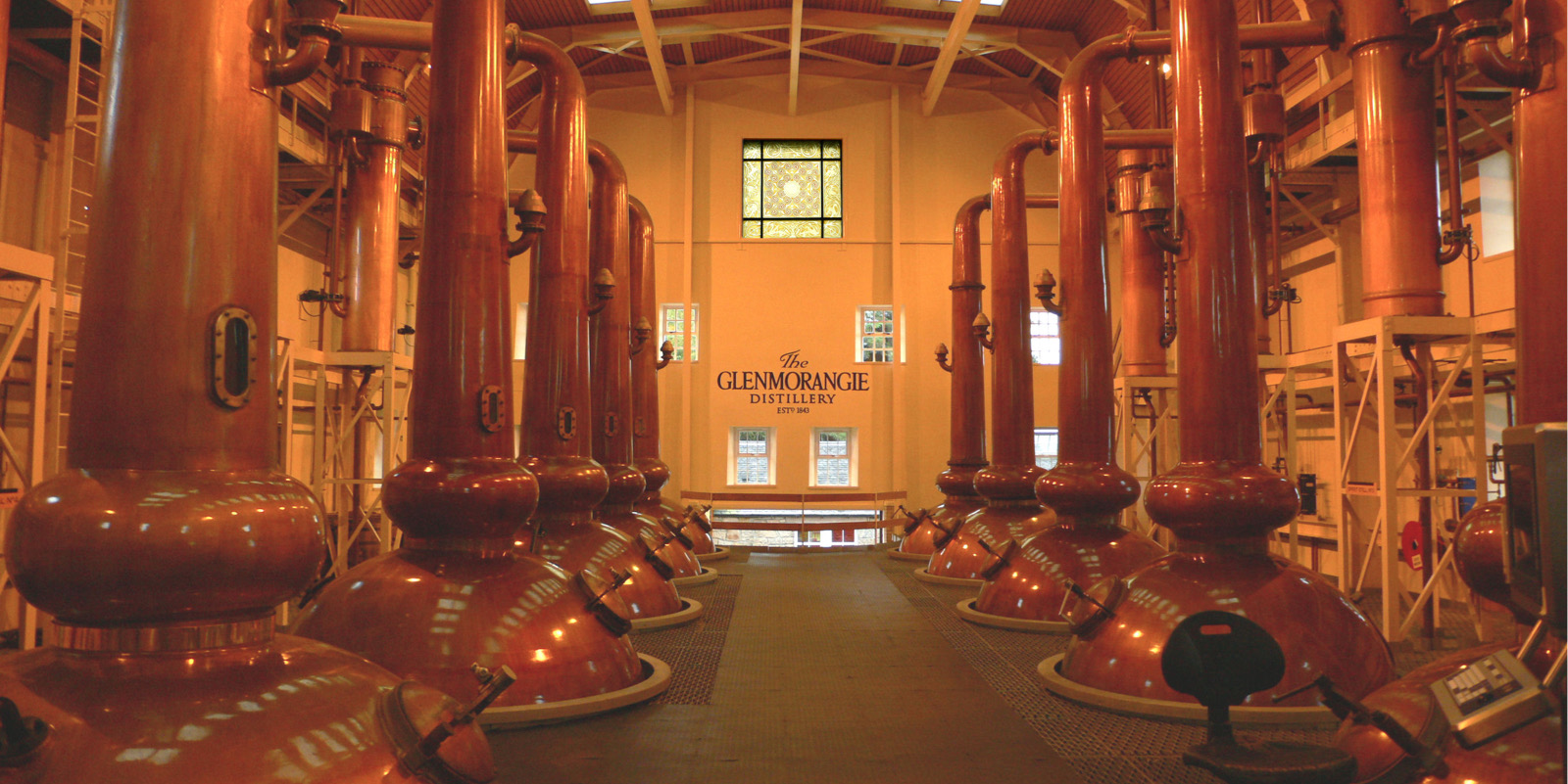 glenmorangie Stillhouse Window - Section of the 10-metre fused glass artwork with copper stills in the background