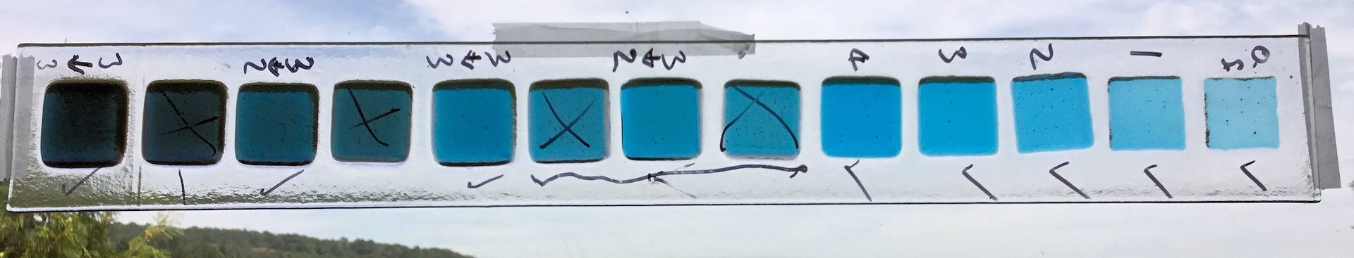 Turquoise octave sample strip — one note across nine octaves in fused Bullseye glass, from deep teal to pale sky blue