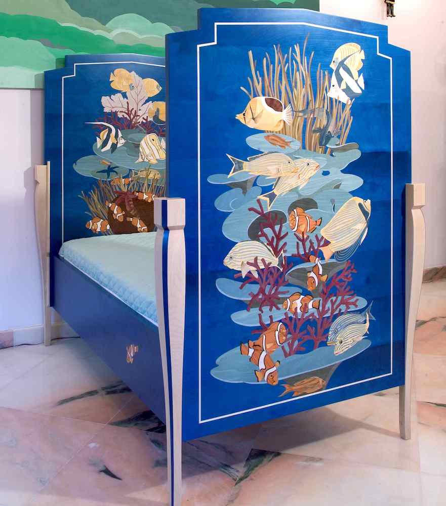 The cobalt blue bed — dyed wood veneers, deep ocean world, designed to convert to a sofa