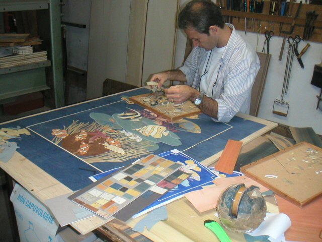 Craftsman assembling the cream bed panel — natural wood veneers only