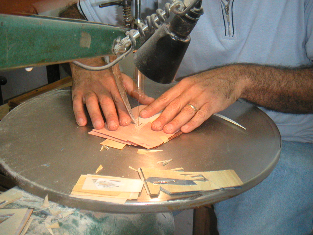 Two blue bed panels laid out in the Sorrento workshop — craftsman examining the composition