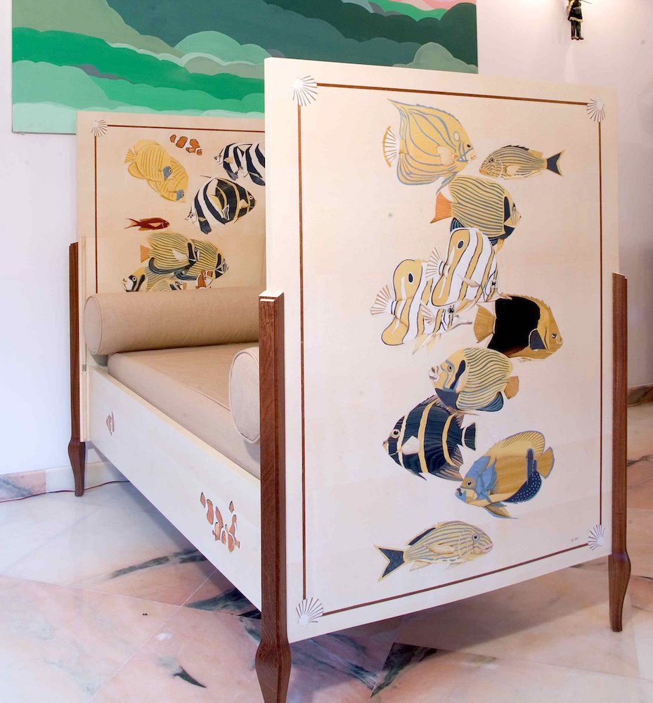 The cream bed — natural wood veneer marquetry, sunlit reef, designed to convert to a sofa