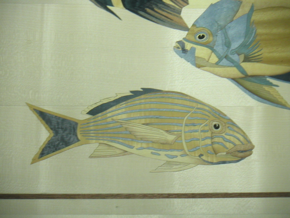 A single clownfish in natural wood veneer marquetry — showing the precision of the cutting technique
