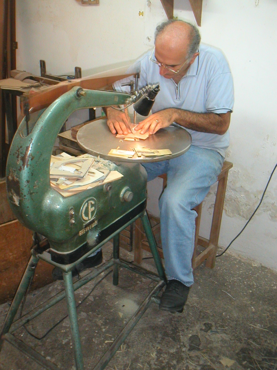 The Sorrento marquetry cutting machine — craftsman cutting stacked veneers with a thin blade